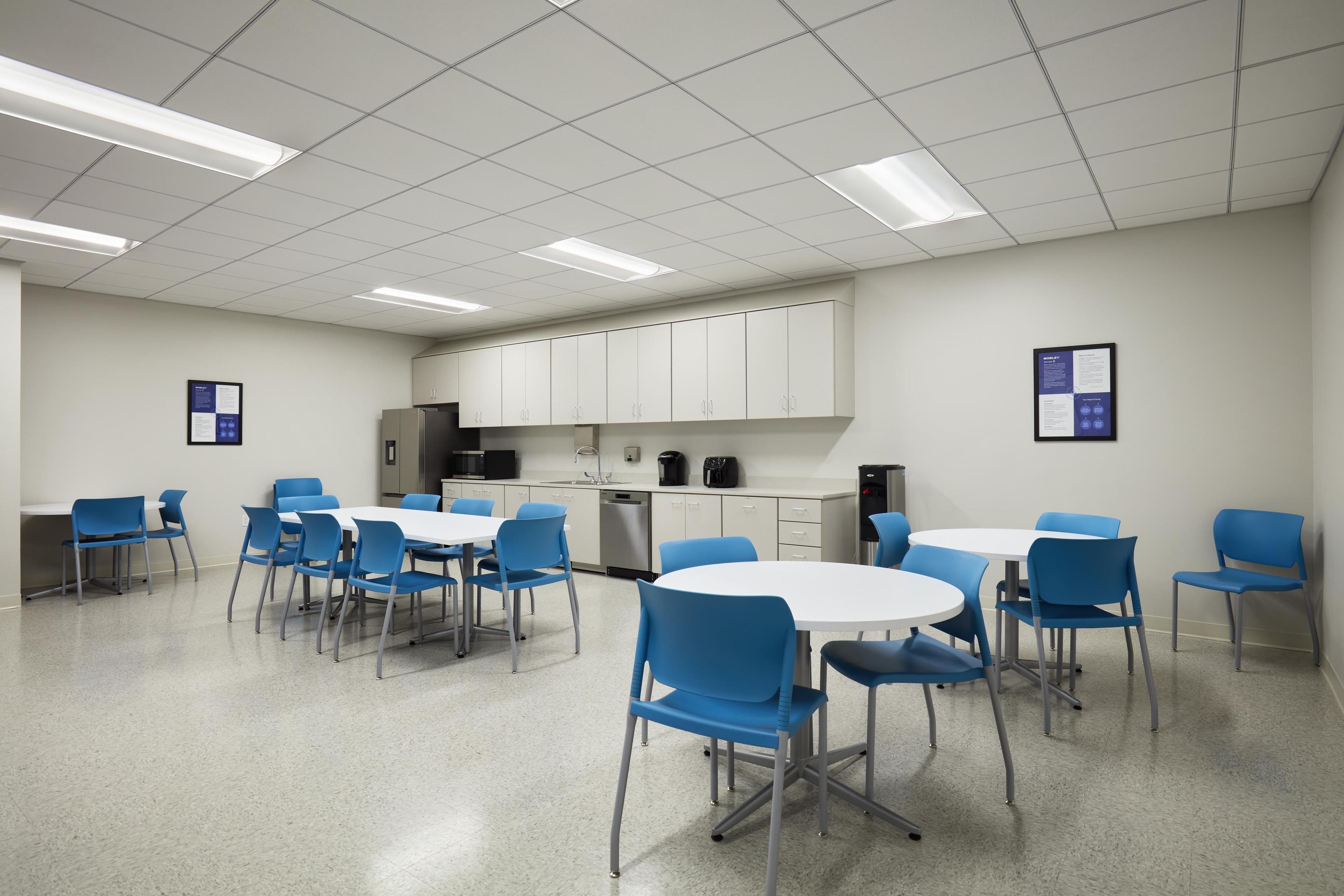 Break room with tables, chairs, and cabinets