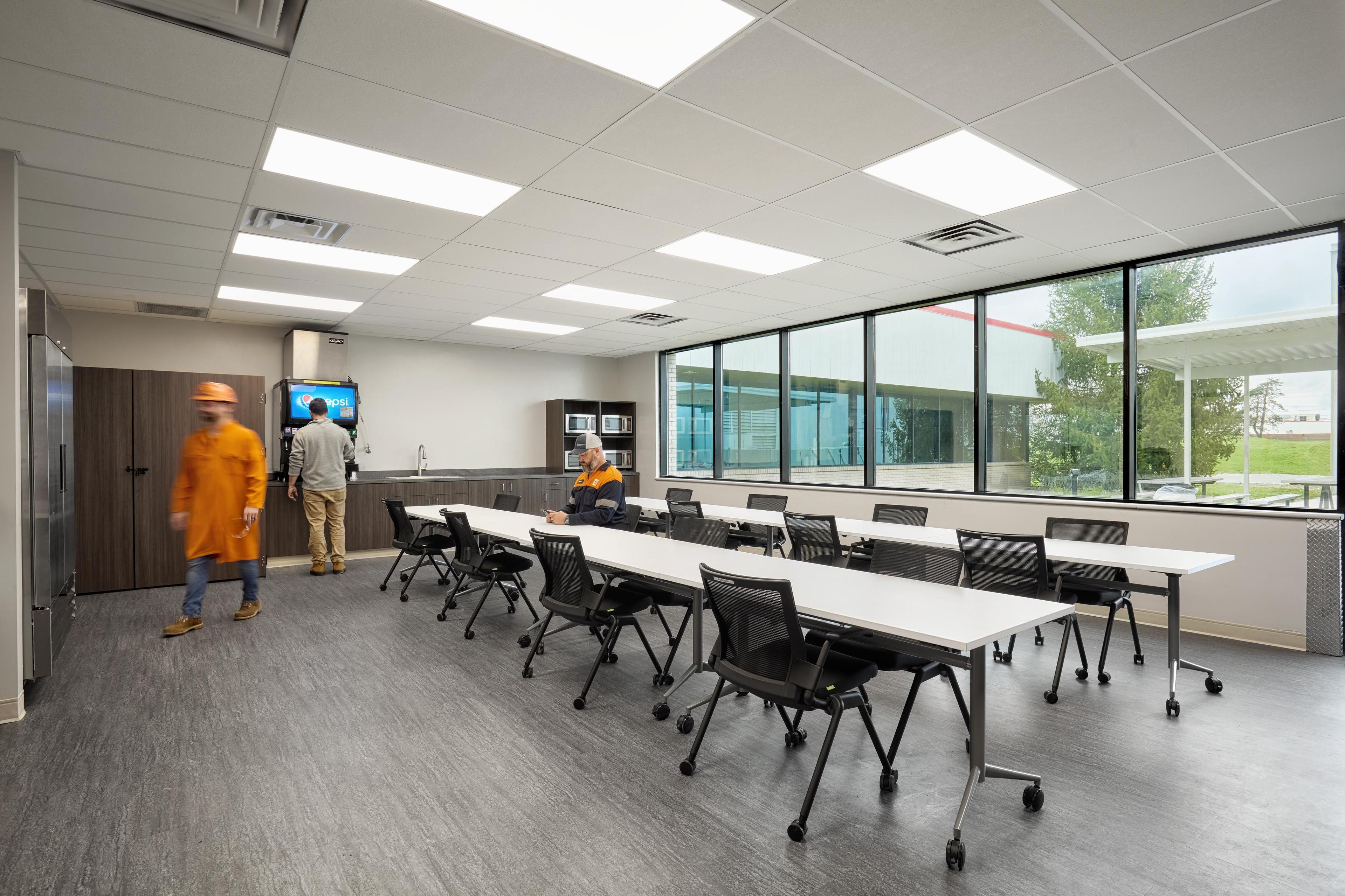 breakroom with large windows, tabes, and chairs