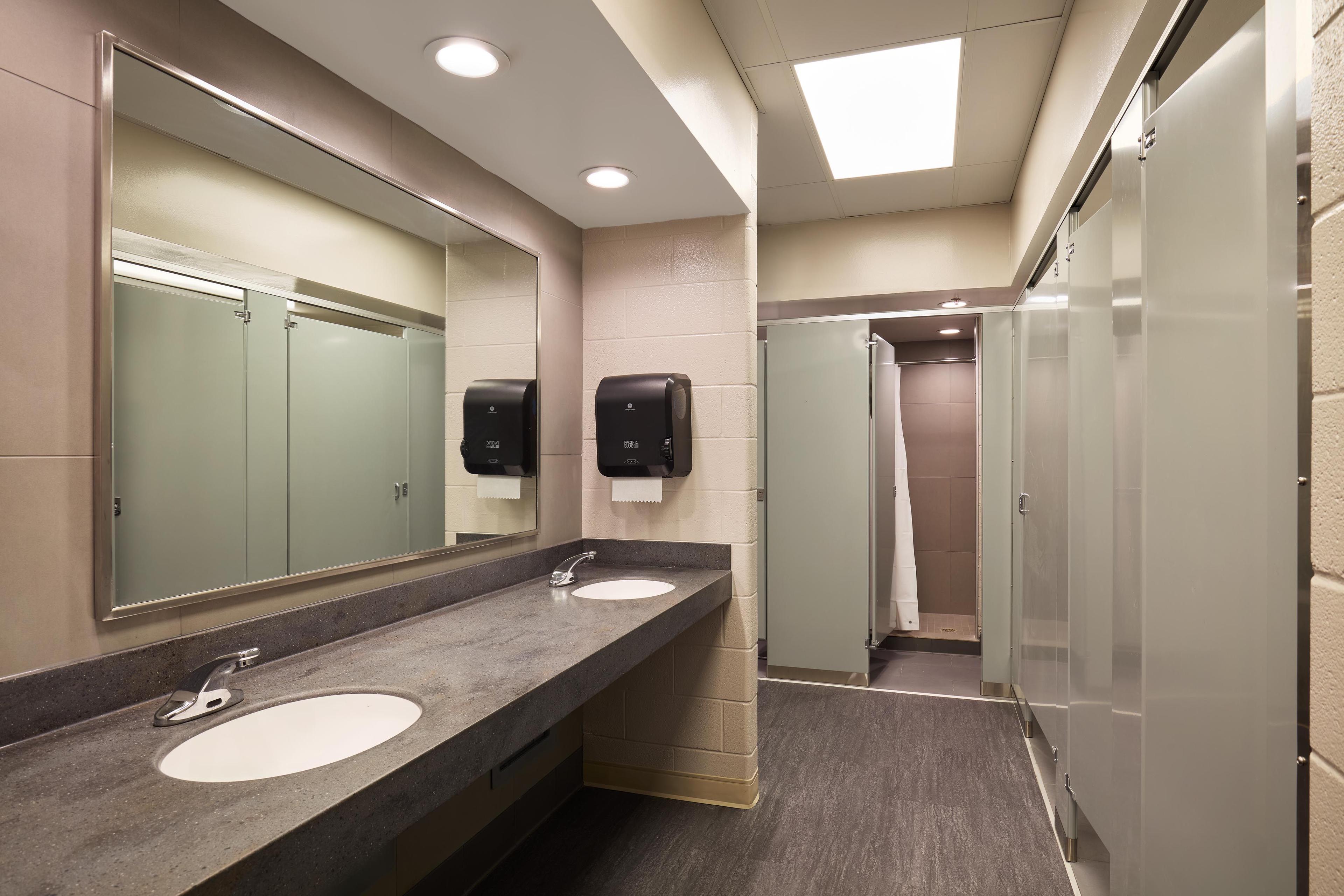 Bathroom sink, mirror, and stalls